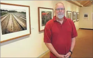  ?? GENE WALSH — DIGITAL FIRST MEDIA ?? Nicolas Bowen stands near some of his work at his photograph­y exhibit “Guest on the Land” at Mennonite Heritage Center in Harleysvil­le June 1.