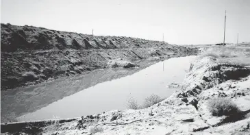  ?? PHOTO COURTESY OF TONY HARRIS ?? Service members deployed to Karshi-Khanabad, Uzbekistan, called these ponds outside the base the “Skittles,” after the candy because they glowed bright green. The ponds were behind a sign that warned of “Radiation Hazard.”