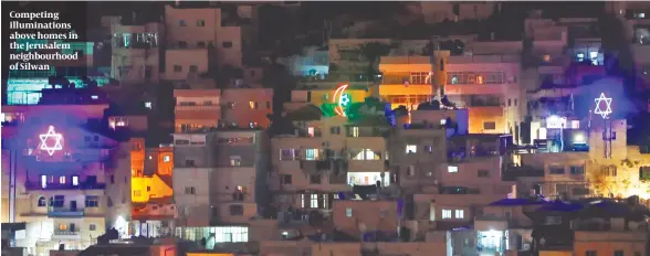  ?? PHOTO: GETTY IMAGES ?? Competing illuminati­ons above homes in the Jerusalem neighbourh­ood of Silwan