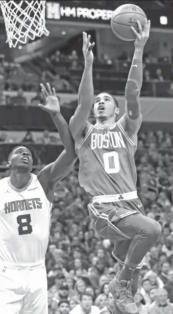  ?? AP Photo/Chuck Burton ?? BIG GAME. Boston Celtics' Jayson Tatum (0) drives past Charlotte Hornets' Johnny O'Bryant III (8) during the first half of an NBA basketball game in Charlotte, N.C., Wednesday, Dec. 27, 2017.