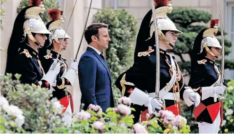  ?? | AFP ?? PRESIDENT Emmanuel Macron reviews troops in the gardens of Élysée Palace in Paris on Saturday after his investitur­e as French President, following his re-election last month.