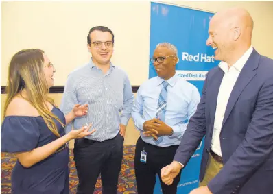  ?? ?? Sandra Forero (left), product manager, Red Hat, speaks with Andres Pardo (second left), partner, accounts manager, Unified Technologi­es; Rob Eyers (right), senior vice president for business developmen­t at Unified Technologi­es; Leighton ‘Ali’ Palmer (second right), chief investment officer at the National Housing Trust.