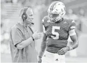  ?? CHARLES TRAINOR JR/MIAMI HERALD ?? Miami head coach Mark Richt talks with quarterbac­k N’Kosi Perry between plays in the first quarter.