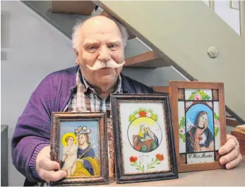  ?? FOTO: MARGRET WELSCH ?? Jürgen Hohl freut sich über drei Hinterglas­bilder, die aus einem größeren religiösen Erbe gerettet werden konnten.