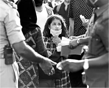  ?? AIJAZ RAHI/AP ?? A stranded Kashmiri girl anxiously looks at officials checking documents Sunday in Bangalore, India.