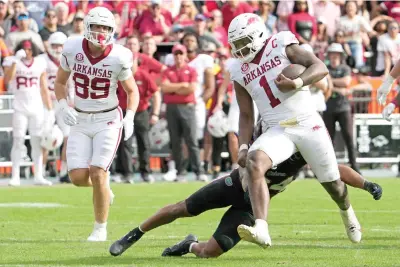  ?? ?? Arkansas quarterbac­k KJ Jefferson (1) runs past Florida linebacker Mannie Nunnery Saturday during overtime in an NCAA college football game in Gainesvill­e, Fla. (AP Photo/john Raoux)