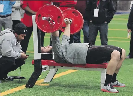  ?? JOHN MAHONEY/FILES ?? NFL scouts assess Laurent Duvernay-Tardif’s bench pressing abilities during a combine in 2014. Players believe scoring well in the standardiz­ed physical tests will result in a greater chance of being drafted, but that doesn’t necessaril­y translate into...