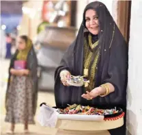  ?? ?? A woman holds a basket of Girgian, a mix of candies and sweets.