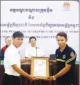  ?? SRENG MENG SRUN ?? Gymnast Sam Rim (right) receives a certificat­e from federation chief Noy Sophanna on December 22, 2016.