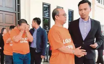  ?? [FOTO JANNAH KHO/BH] ?? Pegawai SPRM Sarawak mengiringi semua suspek selepas mendapatka­n tahanan reman di Mahkamah Majistret Kuching, semalam.