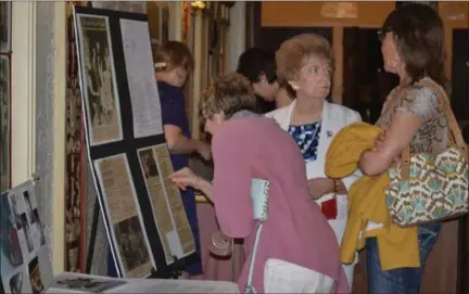  ?? KEITH REYNOLDS — THE MORNING JOURNAL ?? Barbara Macgregor, center, shows a board covered in newspaper clippings about the drive to purchase the Lorain Palace Theater as part of the 40th anniversar­y celebratio­n of that purchase July 8.