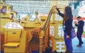  ?? CUI XIAO / FOR CHINA DAILY ?? A visitor in Nanjing, Jiangsu province, checks artwork made of cartons by an exhibitor during an exhibition of products manufactur­ed on the Chinese mainland by Taiwan-invested enterprise­s on Tuesday.