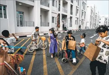  ?? Photograph­s by Marcus Yam Los Angeles Times ?? ARWA GHANEM, 10, in a wheelchair, and other Palestinia­ns play in a compound housing Gazan medical evacuees in Doha, Qatar. A wardrobe fell on Arwa during an Israeli attack, pulverizin­g the bones in her left leg.