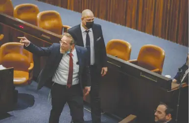  ?? (Olivier Fitoussi/Flash90) ?? MK YITZHAK PINDRUS points an accusing finger, as he is escorted out of the Knesset plenum during a stormy debate, in February.