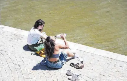  ?? MIGUEL MOLINA /EFE ?? Una joven bebe agua en la orilla del río Genil a su paso por Granada, ayer.