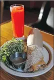  ??  ?? A sweet potato burrito, the restauran’ts signature item, with sprout salad accompanie­d by the house lemonade.