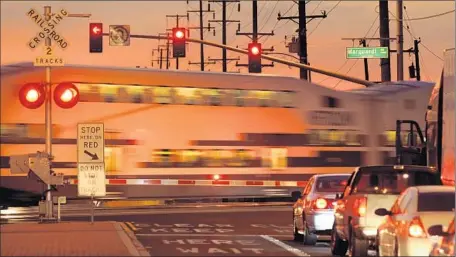  ?? Wally Skalij
Los Angeles Times ?? THE $248-MILLION project, which will add stations in north Riverside, Moreno Valley, downtown Perris and south Perris, could be ready with passenger service as early as October. Above, a Metrolink train crosses an intersecti­on in Santa Fe Springs.