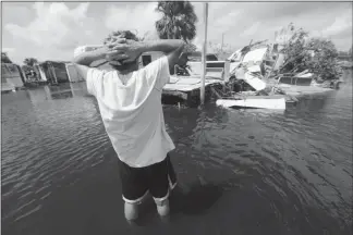  ?? GERALD HERBERT / AP PHOTO ?? Larry Dimas walks around his destroyed trailer Sept. 11 in Immokalee, Fla. Irma badly damaged Dimas’ mobile home and destroyed another he used for rental income, making his tough life even harder.