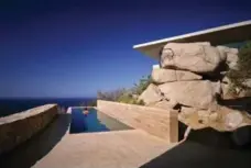  ??  ?? The lap pool is cantilever­ed out over the cliff and flanked by stone walls.