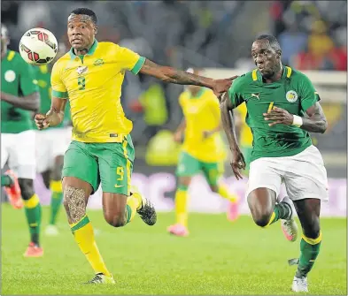  ?? Picture: LEFTY SHIVAMBU/GALLO IMAGES ?? UPFRONT MAN: Bafana’s Thamsanqa Gabuza fends off Issa Cissokho of Senegal in the Nelson Mandela Challenge match in September. SA will need an aggressive Gabuza to lead the attack against Angola tomorrow.