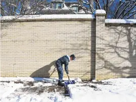  ??  ?? Midshipmen 1st Class Tony Janssen, from 11th Company, shovels the sidewalk on King George Street.