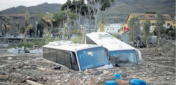  ?? REUTERS ?? Un desastre. El sábado llovieron 130 milímetros en pocas horas, lo que disparó un deslave en un cerro. En la imagen, la avalancha de piedras casi tapan a dos vehículos.