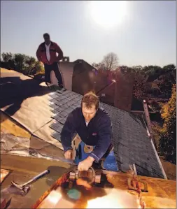  ?? TONY BOCK/TORONTO STAR ?? Diethart Metzner, front and Peter Dann, of Let It Rain, work on a roof.