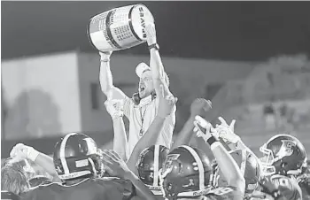  ?? CHRIS HAYS/ORLANDO SENTINEL ?? Edgewater coach Camerons Duke holds up the Spirit Barrel after the Eagles beat Boone for the third consecutiv­e year.