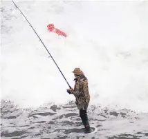  ?? Picture / Bryce Bedford ?? The Muriwai rock fisherman disappears in a sea of foam as a wave knocks him off his feet.