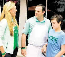  ?? David Hopper / For the Chronicle ?? Ragin’ Cajun owner Dominic Mandola visits with Missy Herndon of The Woodlands and her son, Will. The restaurant held its grand opening recently and 15 percent of all money earned during the event went to HOPE: The Will Herndon Fund for Juvenile Batten...