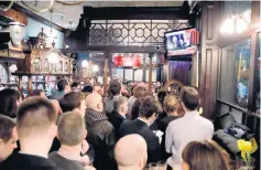  ??  ?? Británicos siguen el discurso de la primera ministra Theresa May ante el Parlamento en un bar en Londres.