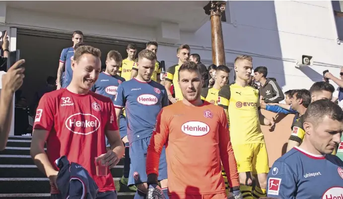  ?? Fotos: Michael Trampert ?? Die Spieler von Borussia Dortmund (gelb) und Fortuna Düsseldorf (blau) beim Gang aufs Spielfeld.
