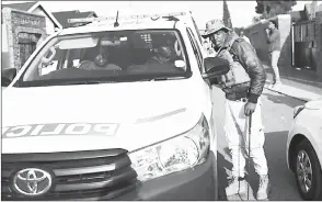  ?? (Pic: Alaister Russell) ?? Activist Nhlanhla ‘Lux’ Dlamini talks to police officers outside his Pimville house in Soweto, Johannesbu­rg.