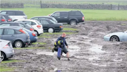  ??  ?? A festival goer struggles to get to his vehicle