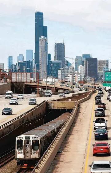  ?? ANTONIO PEREZ/CHICAGO TRIBUNE ?? Traffic flows along the I-94 Dan Ryan expressway as a CTA Red Line train heads north toward Chicago’s downtown skyline, near the start of rush hour on March 18.