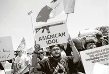  ?? Celia Talbot Tobin / New York Times file photo ?? Demonstrat­ors hold signs at a rally to protest President Donald Trump’s visit in 2019 at El Paso’s Washington Park.