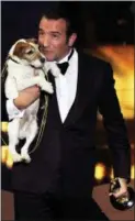  ?? MARK J. TERRILL — THE ASSOCIATED PRESS ?? In this Feb. 26, 2012, photo, Jean Dujardin holds Uggie the dog after accepting the Oscar for best picture for “The Artist” during the 84th Academy Awards in Los Angeles.