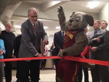  ?? KEVIN MARTIN — THE MORNING JOURNAL ?? Avon Lake Mayor Greg Zilka cuts the ribbon at the grand opening of The Anchor recreation facility at 33483 Lake Road on Feb. 21 with assistance from Cleveland Cavaliers mascot Moondog. The project in developmen­t for the past two years includes a 70x100...