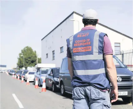  ?? Photo: James Beck ?? A member of Team Rubicon helping manage the queue of cars at Keynsham Recycling Centre, which reopened on Wednesday, as part of Operation Re:Act