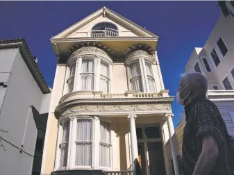  ?? Paul Kuroda / Special to The Chronicle ?? Denny Smith, who got his first COVID vaccinatio­n last week, admires curved glass of a Victorian home in San Francisco. “I go out every day, or else I’d go crazy,” said Smith, 68.