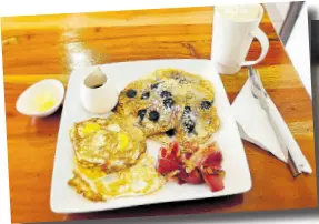  ?? ?? Indulge in all-day breakfast featuring scrumptiou­s blueberry pancakes, fried eggs, crispy bacon, and heart-warming hot chocolate.