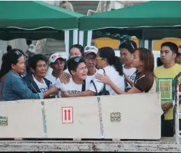  ??  ?? BITTER REUNION – Joyce Demafelis (center) wails as the wooden box containing the remains of her sister Joanna arrives at Iloilo Internatio­nal Airport. Mother Eva (in black jacket) and other family members fetched Joanna, the Filipina house helper who...