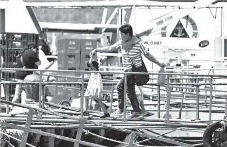  ?? MACKY LIM ?? HOLD ON TIGHT. A mother holds tight her daughter as they cross the bridge from the boat upon arriving at Sta. Ana Pier in Davao City yesterday morning.