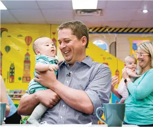  ??  ?? Scheer, the federal Conservati­ve party leader, holds a four-month-old baby in Toronto