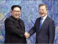  ?? KOREAN SUMMIT PRESS POOL VIA AP ?? North Korean leader Kim Jong Un, left, poses with South Korean President Moon Jae-in for a photo inside the Peace House at the border village of Panmunjom in Demilitari­zed Zone Friday.