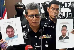  ??  ?? Suspects in custody: Commission­er Asri showing pictures of the two wanted men during a press conference held before the duo turned themselves in.