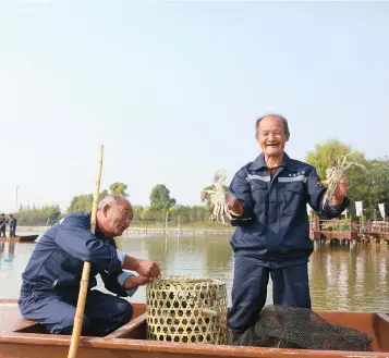  ??  ?? A man shows large Chongming freshwater crabs he has harvested. — Zhou Tianshu