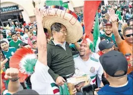  ?? Michael Owen Baker For The Times ?? HAROLD LEE, a Torrance resident who’s originally from South Korea, is hoisted by Mexico fans at a viewing party in Lynwood. Lee says he’s a Mexico soccer fan.