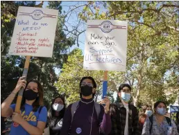  ?? ZAYDEE SANCHEZ — CALMATTERS ?? Students hold signs while listening to UCLA faculty members share their stories of unfair wages on Oct. 13, 2021.