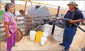  ?? ALEXA ROGALS/THE DAILY TIMES VIA AP ?? Resident Sarah Frank, left, talks with Richard Root, an equipment operator for the Shiprock Chapter House, as he fills up barrels of water for her livestock in Shiprock on Aug. 11. Officials in communitie­s downstream from where millions of gallons of...